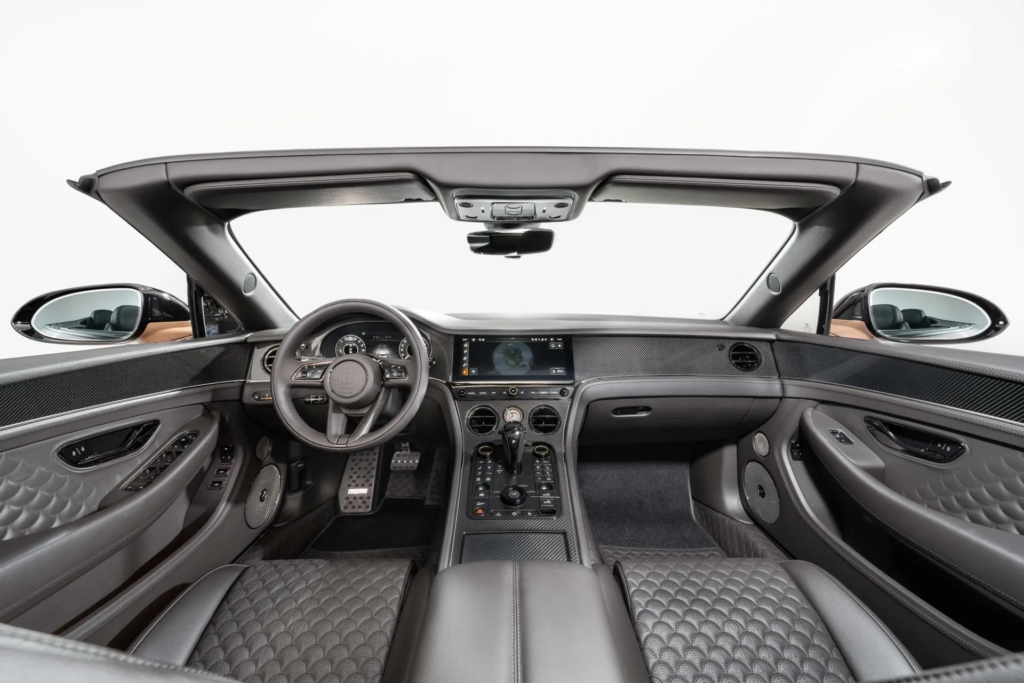 The interior of the Brabus 900 convertible blends absolute luxury with handcrafted sportiness. Custom-made perforated leather upholstery, diamond stitching, carbon fiber inserts, and personalized controls define a unique finish, in the purest tradition of high-performance GT cars. © Brabus